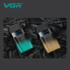 A pair of VGR electric beard trimmers, one teal and one gold, displayed on a dark textured surface.