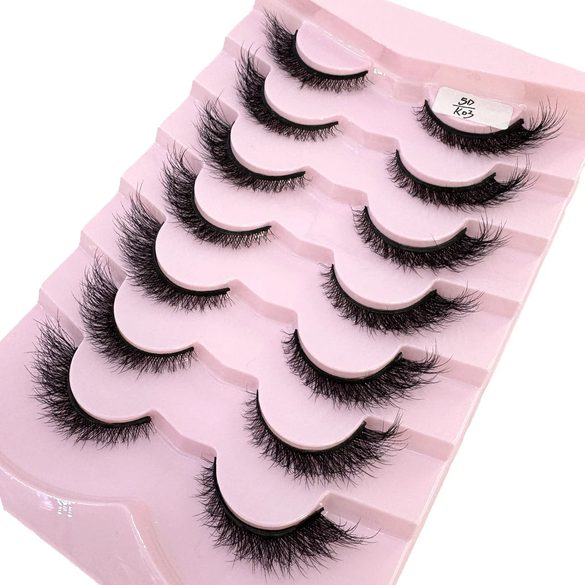Plateau en plastique rose contenant divers styles de faux cils de renard noirs.