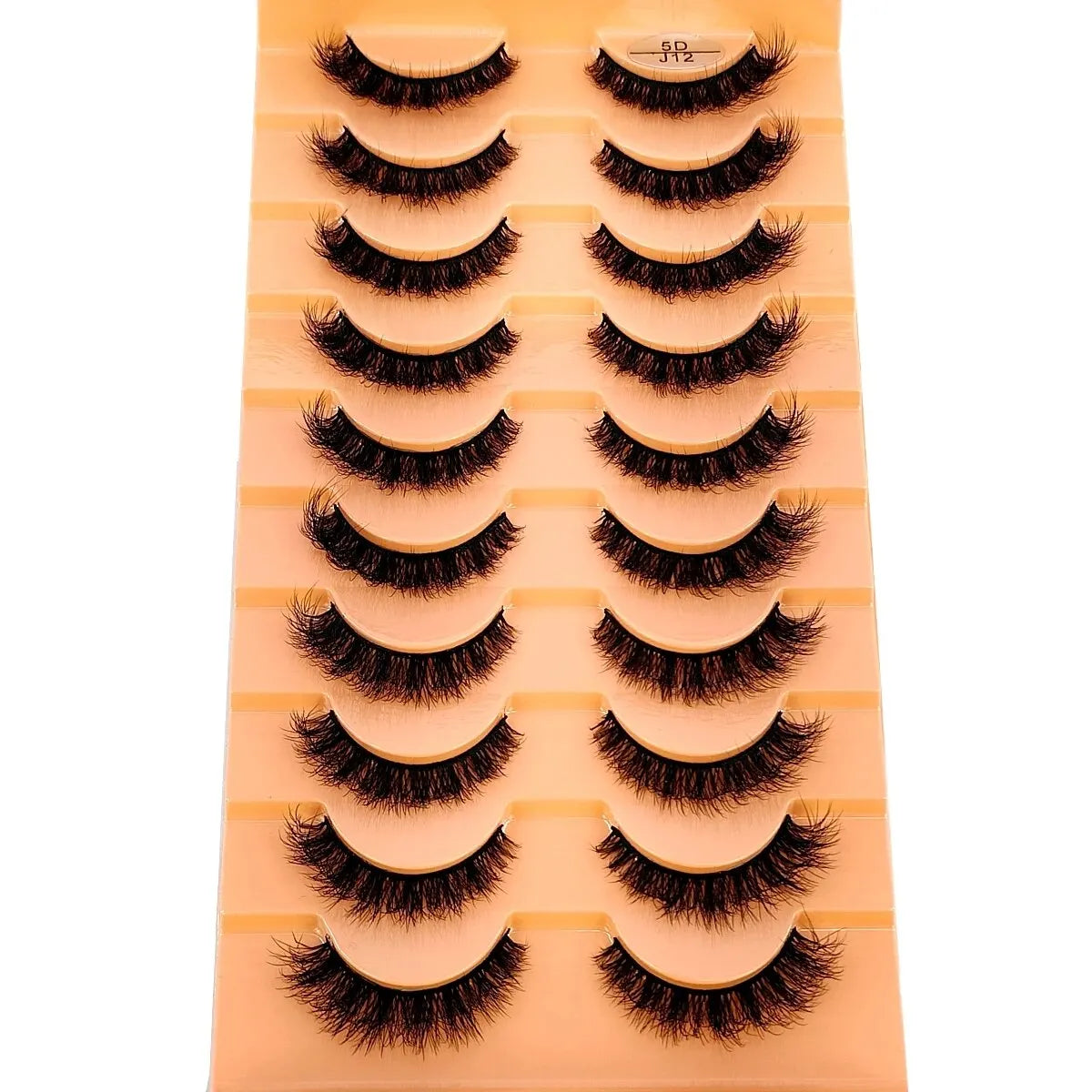 Un plateau présentant divers styles de faux cils de renard fabriqués à la main dans des tons noirs et bruns.