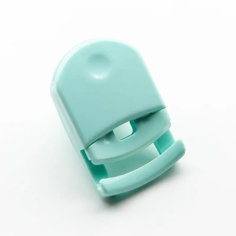 A light mint green mini folding eyelash curler set shown from above.