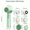A close-up view of a light green ultrasonic facial cleansing brush with various interchangeable heads and charging components