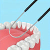 Un raspador de lengua de acero inoxidable posicionado contra los dientes de una persona para la higiene bucal.