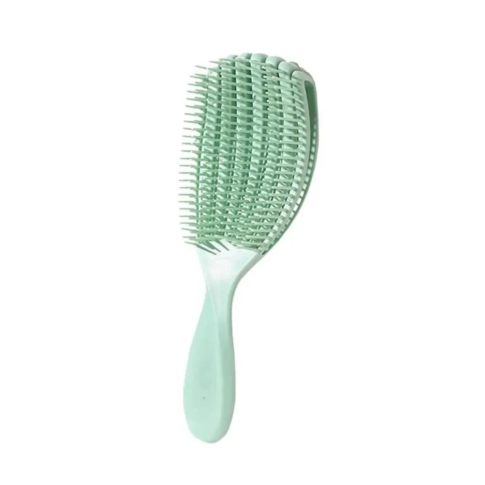 A light green massage detangler hair brush with flexible bristles.