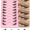 A pink plastic tray holding multiple pairs of clear band cat eye false eyelashes and loose lashes.