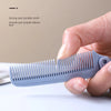 A hand holds a light blue portable folding hairbrush with triangular dense teeth on a white surface.