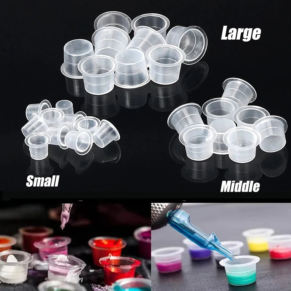 A set of tattoo ink cups with holders in large, middle, and small sizes displayed on a dark surface.