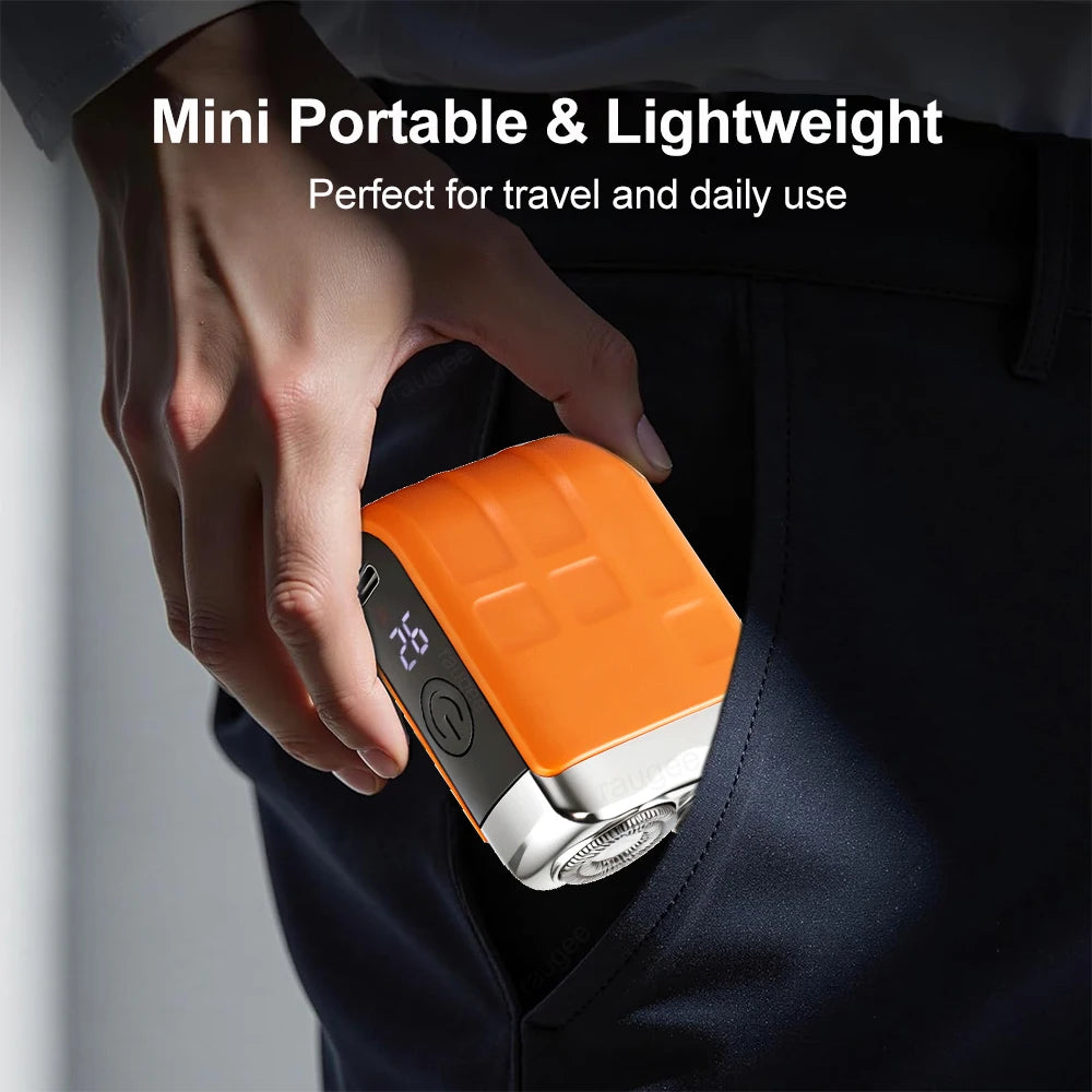A hand holds an orange and silver mini portable electric beard trimmer against a dark blue shirt.