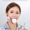 A woman demonstrates a 360 degree automatic sonic electric toothbrush, showing how it can be used without hands.