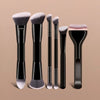 A set of six dual-ended makeup brushes with black handles and fluffy, light gray bristles displayed on a neutral background.