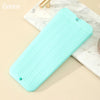 A light green heat resistant silicone mat with ridges is shown on a marble surface.