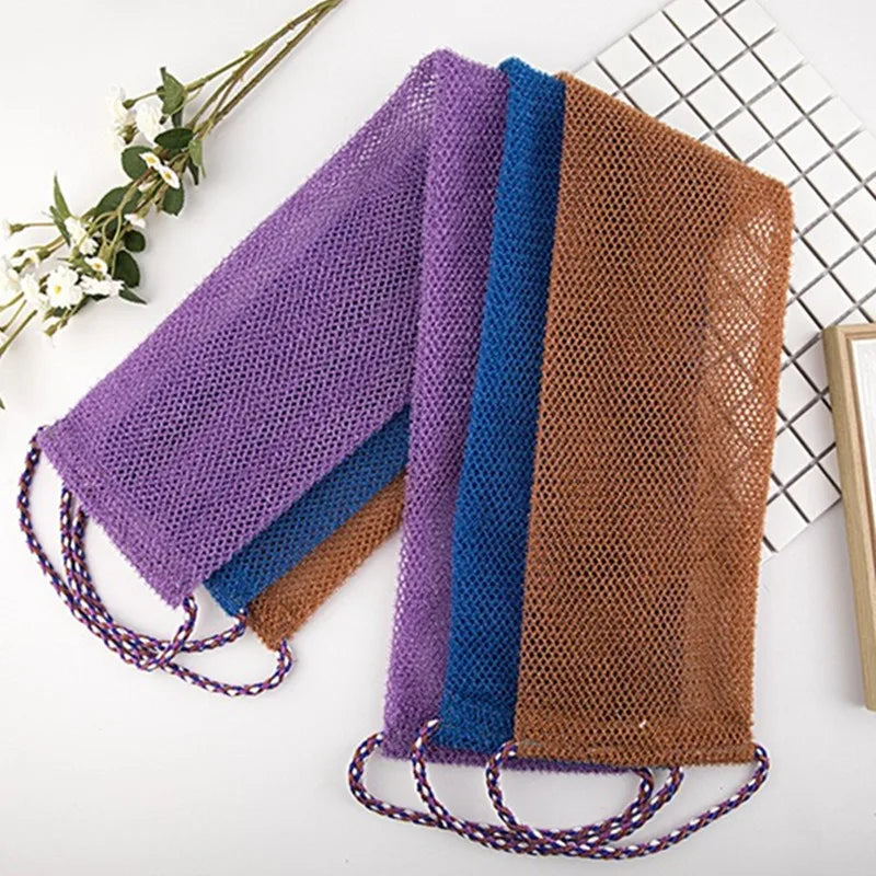 A collection of exfoliating African net body scrub sponges in purple, blue, and brown are displayed on a white surface.