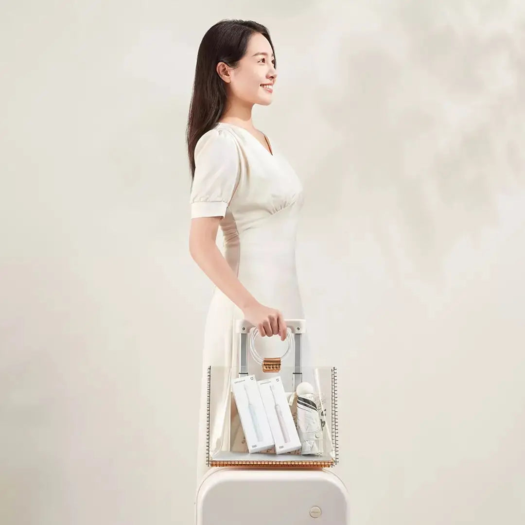 A woman is holding a white sonic electric toothbrush with dual cleaning modes in a light-colored setting.