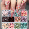 A set of 3D floral butterfly pearl nail art charms featuring various shades of pink and purple flowers on fingernails.