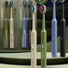 Un set de brosses à dents professionnelles à double poil de différentes couleurs, présentées dans un emballage vert et gris.