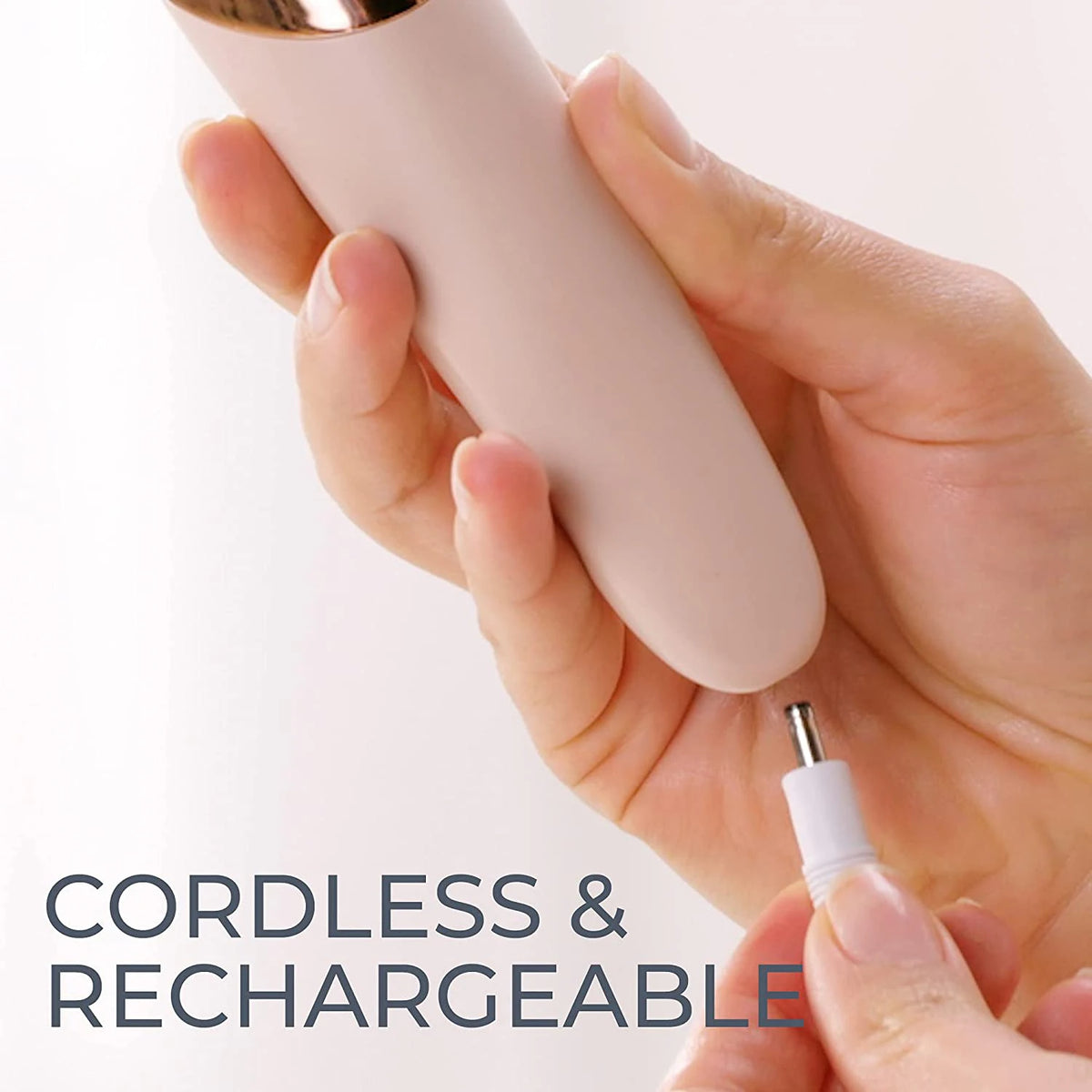 Une main tient un appareil électrique rechargeable et sans fil pour poncer les pieds ou retirer les callos.
