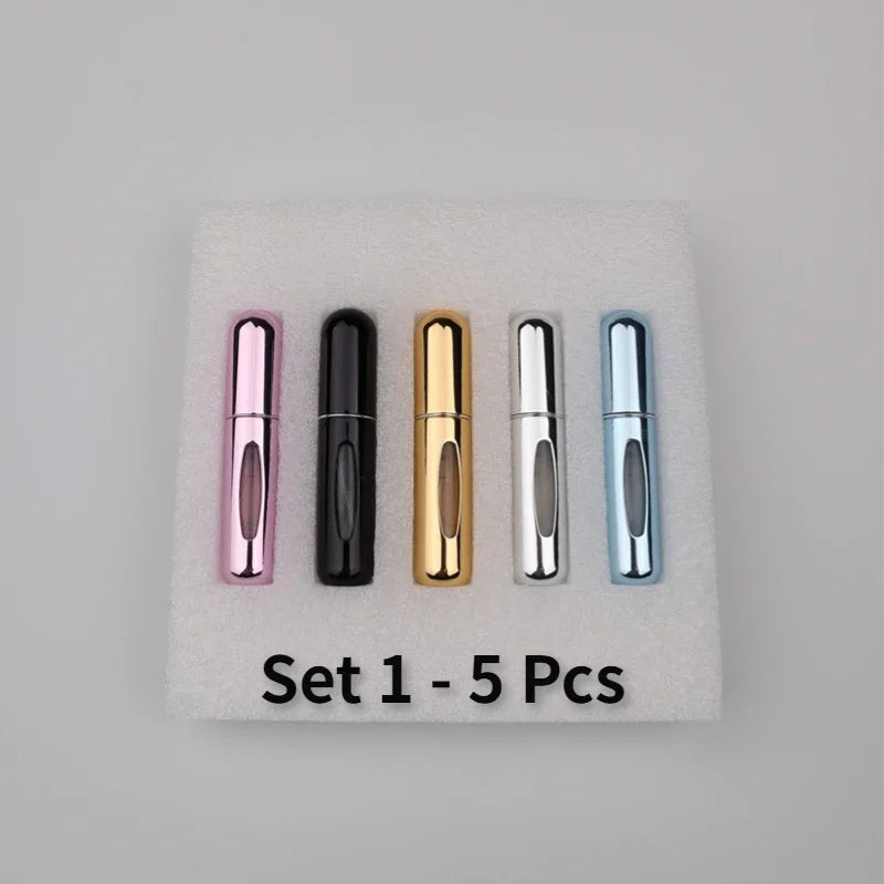 A set of five refillable mini perfume spray bottles in various colors including pink, black, gold, silver, and blue, displaye
