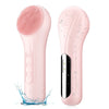 A pink sonic facial cleansing brush with a textured silicone head is shown next to its body, with water splashing around it.