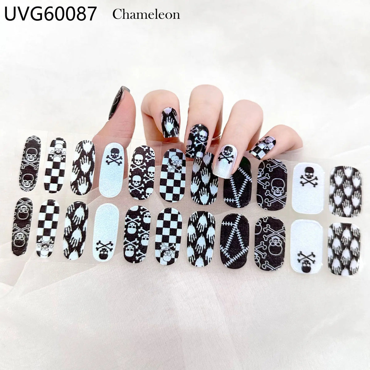 A hand displays various Halloween themed UV gel nail stickers on the fingernails.