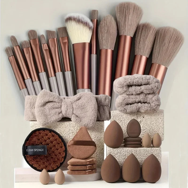 A collection of professional makeup brushes and sponges in various shades of brown and beige.