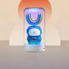 A blue electric toothbrush for kids is displayed inside a clear cylindrical device with a glowing light.