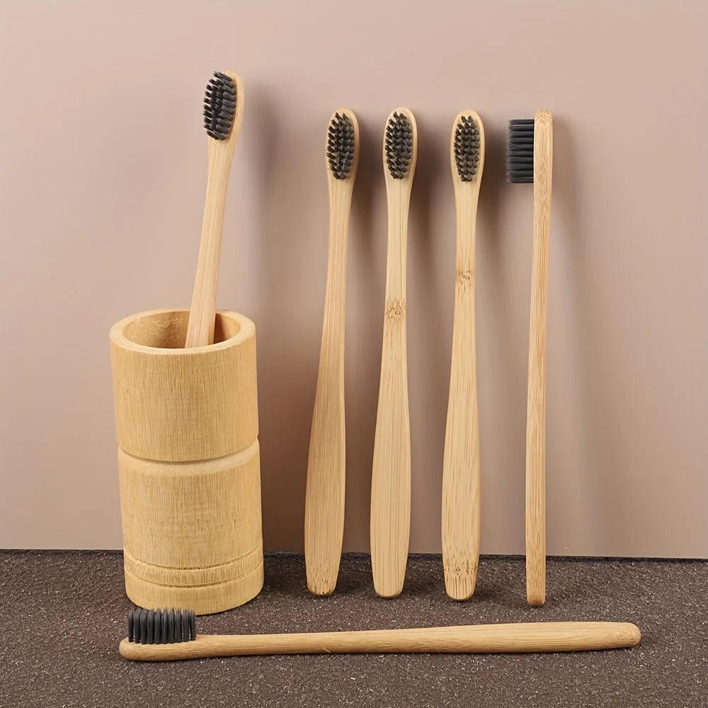 A set of six bamboo toothbrushes with varying bristles are displayed against a neutral background.