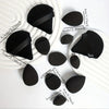 A collection of twelve black all-purpose makeup sponges arranged on a white surface.