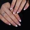 A hand displaying almond press-on nails with a pink bow design on a medium length set.