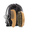 A set of a wooden beard brush and comb with boar bristles inside a black fabric gift bag.
