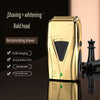 A gold electric shaver with a bald head and accessories is shown on a dark surface.