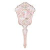 A delicate pearl hand mirror with a pink, ornate frame and a sculpted face design.