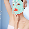 A woman is wearing a light green face mask with a patterned design, demonstrating the 8 color light mask for skin rejuvenatio