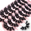 A close-up of natural mink striped false eyelash extensions arranged on a pink surface.