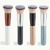 A set of four flat top makeup brushes with varying handles and bristles shown against a white background.