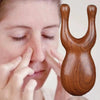 A wooden sandalwood massager comb set is shown being used on a person's nose.