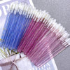 A collection of crystal lip brushes and lash spoolies in various shades of blue, purple, and white.