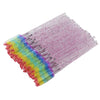 Un ensemble de pinceaux à cils jetables de différentes couleurs : rose, violet, bleu et vert.
