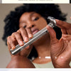 A close-up of a silver double-edge safety razor with a protective guard and a cleaning strip resting on a white towel.