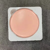 A round, light pink makeup mirror with a luminous effect is shown in its white plastic packaging.