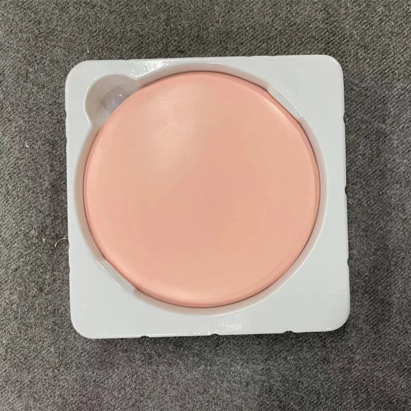 A round, light pink makeup mirror with a luminous effect is shown in its white plastic packaging.