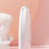 A white, oval-shaped LED makeup mirror is shown against a soft pink background.