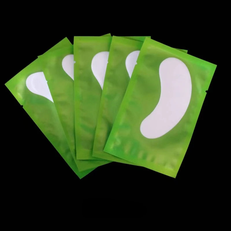A fan of green under-eye lash application patches, showing several individual patches.