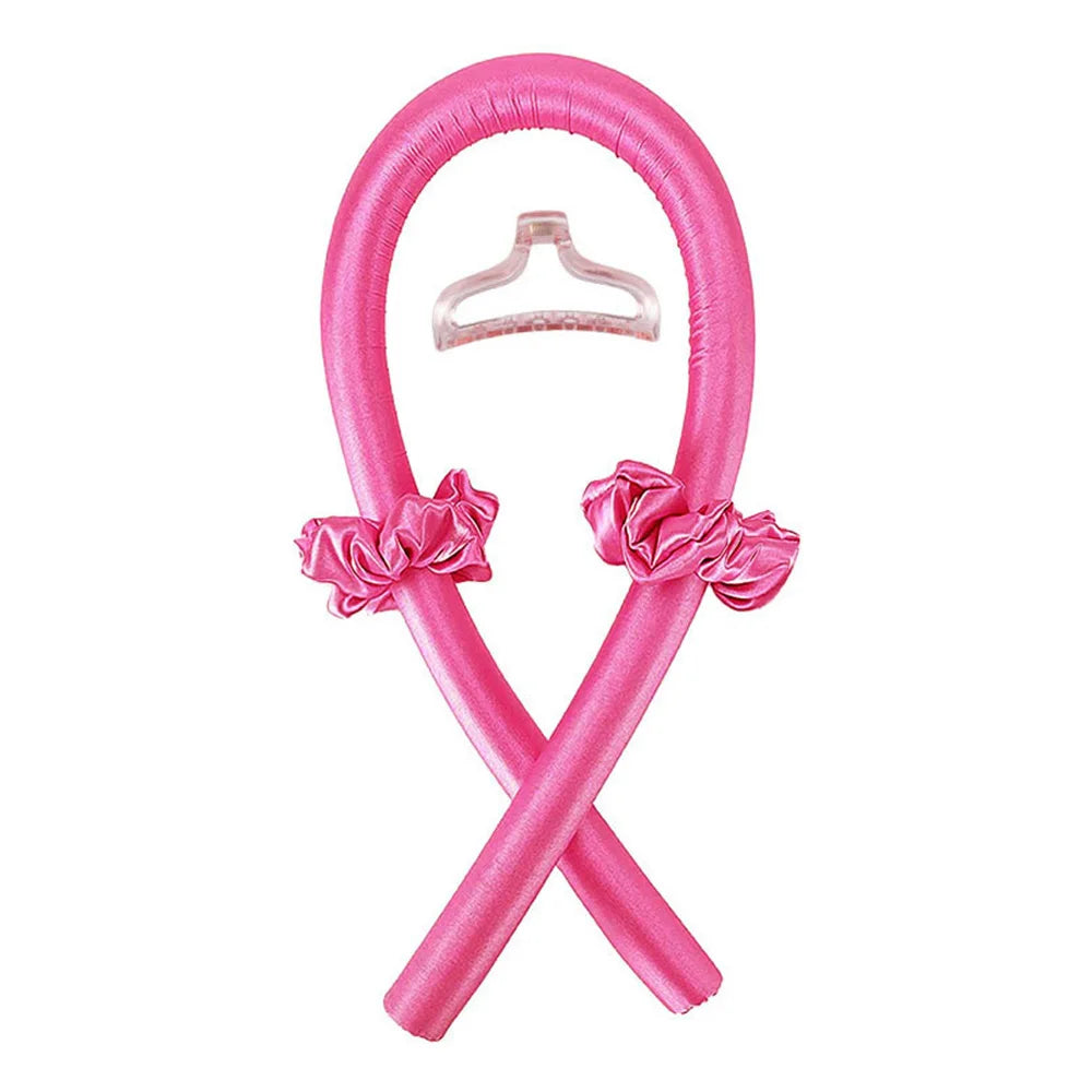 A pink satin heatless curling set with a bow detail, shaped like an 'X'.