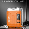 An orange portable shaver is shown resting on a silver suitcase or luggage.