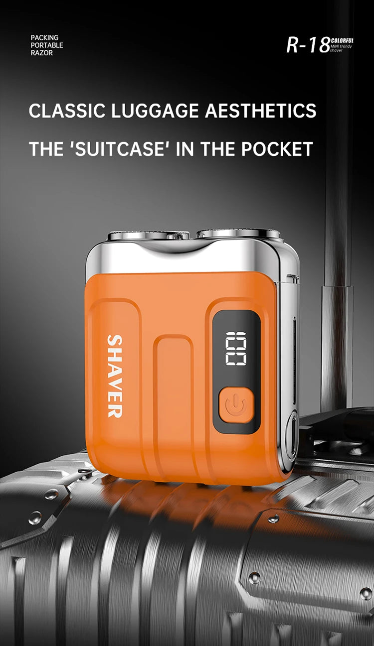 An orange portable shaver is shown resting on a silver suitcase or luggage.