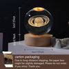 A spherical glass crystal ball night light resting on a wooden base.