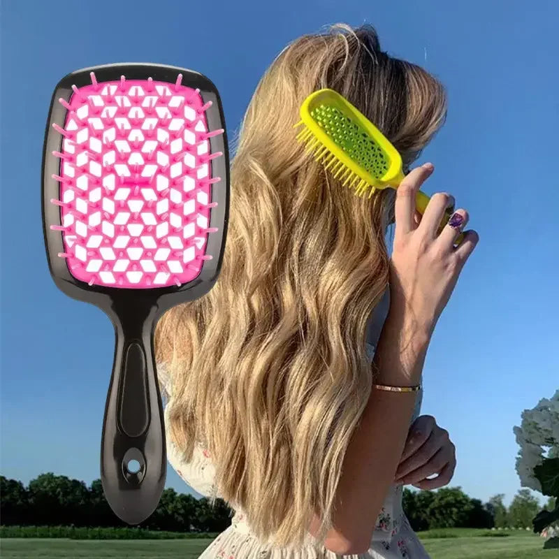Una mujer usa un peine ancho para desenredar de dientes anchos amarillo en su largo cabello rubio al aire libre.
