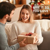 A couple is shown in a cozy setting, with a woman smiling while holding a gift box.