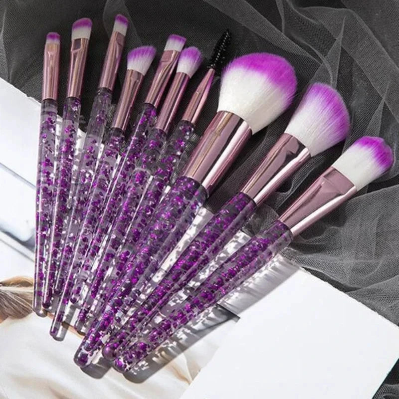 A set of ten professional makeup brushes with purple and pink bristles and metallic handles displayed on a dark background.