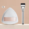 An XL triangular cosmetic foundation puff brush with a silver handle and white silicone head.