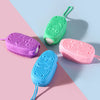 Three silicone body brushes in green, purple, and pink are displayed on a light blue background.